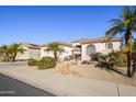 Single-story home with inviting front yard, palm trees, and a two-car garage at 17824 W Addie Ln, Surprise, AZ 85374