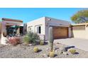Front view of a charming single story home with a spacious driveway and drought-tolerant landscaping at 18658 E Mazatzal Cir, Rio Verde, AZ 85263