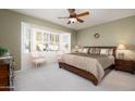 Large main bedroom with window seating and ceiling fan at 20516 N Vermillion Cliffs Dr, Surprise, AZ 85387