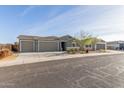 Single-story house with a three-car garage and desert landscaping at 2476 N Abbey Rd, Casa Grande, AZ 85122