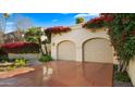 Two-car garage with terracotta driveway and bougainvillea at 7500 E Mccormick Pkwy # 11, Scottsdale, AZ 85258