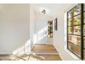 Bright condo entryway with white door and wood-look floors at 8625 E Belleview Pl # 1149, Scottsdale, AZ 85257