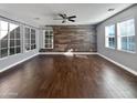 Bright living area featuring wood-look floors and a rustic accent wall at 10510 E Neville Ave, Mesa, AZ 85209