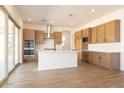 A modern kitchen featuring stainless steel appliances, an island with a white countertop and wood-look tile floors at 1350 E Prescott St, Gilbert, AZ 85298