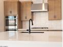 Close-up of the kitchen island featuring quartz countertops, sleek black faucet and stainless steel stove at 1350 E Prescott St, Gilbert, AZ 85298
