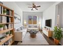 Bright living room featuring a white sectional sofa and built-in shelving at 37855 W Merced St, Maricopa, AZ 85138