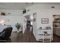Bright entryway featuring wood-look floors, white walls, and an open view to the living room and dining area at 6352 W Campo Bello Dr, Glendale, AZ 85308
