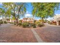 Picturesque view of a landscaped roundabout with mature trees leading to elegant homes in a peaceful desert community at 6411 S River Dr # 10, Tempe, AZ 85283