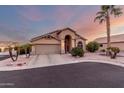 Tan house with a two-car garage and palm trees at 11623 W Lemon Ct, Surprise, AZ 85378