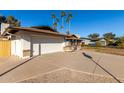 White house with a two-car garage and gravel driveway at 2664 W Ocaso Cir, Mesa, AZ 85202