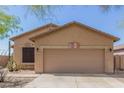 Tan house with a two-car garage and desert landscaping at 6416 E Hacienda La Noria Ln, Gold Canyon, AZ 85118
