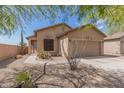Tan house with a two-car garage and desert landscaping at 6416 E Hacienda La Noria Ln, Gold Canyon, AZ 85118