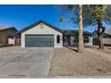 Newly remodeled home with gray garage door and driveway at 6934 W Mclellan Rd, Glendale, AZ 85303