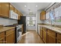 Kitchen features wood cabinets, granite countertops, and stainless steel appliances at 20948 N Sansom Dr, Maricopa, AZ 85138