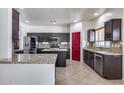 Kitchen with dark cabinetry, granite counters, and stainless steel appliances at 225 N 236Th Ave, Buckeye, AZ 85396