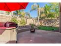 Stone patio with fire pit, grill, and putting green at 2614 W Florimond Rd, Phoenix, AZ 85086