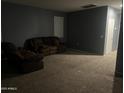 Cozy living room with carpet and a comfortable brown reclining sofa at 30770 W Mitchell Dr, Buckeye, AZ 85396