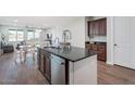 Island kitchen with dark wood cabinets and granite countertops at 3392 E Strawberry Dr, Gilbert, AZ 85298