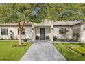 Beautifully landscaped walkway leading to a modern home's striking black front door at 3710 E Hazelwood St, Phoenix, AZ 85018