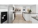 Kitchen with stainless steel refrigerator, granite counters and white cabinets at 38130 W Bello Ln, Maricopa, AZ 85138