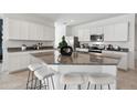 Kitchen with white cabinets, granite island, and stainless steel appliances at 38130 W Bello Ln, Maricopa, AZ 85138