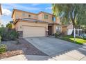 Two-story house with beige exterior, landscaping, and a two-car garage at 9931 W Odeum Ln, Tolleson, AZ 85353
