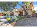 Two-story house with a beige exterior, landscaping, and a two-car garage at 9931 W Odeum Ln, Tolleson, AZ 85353
