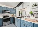 Modern kitchen with blue cabinets, stainless steel appliances, and quartz countertops at 10103 E Olla Ave, Mesa, AZ 85212