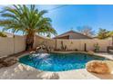 Inviting kidney-shaped pool with waterfall feature in a landscaped backyard at 10103 E Olla Ave, Mesa, AZ 85212