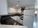 Clean galley kitchen with white cabinets and dark countertops at 12221 W Bell Rd # 363, Surprise, AZ 85378