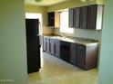 Galley kitchen with dark wood cabinets and tile floor at 1340 E Crescent Ave, Mesa, AZ 85204