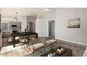 Open concept dining area with kitchen view and modern light fixture at 13859 N 91St Ln, Peoria, AZ 85381