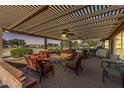 Covered patio with seating area, ceiling fan, and views of the golf course at 15220 W Blue Verde Dr, Sun City West, AZ 85375