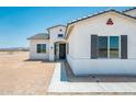 Close up of a single-story home with a dark front door, gray shutters, and desert landscaping at 25505 W Brookhart Way, Wittmann, AZ 85361