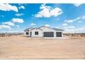 Charming white stucco home featuring a three-car garage and desert landscape at 25505 W Brookhart Way, Wittmann, AZ 85361