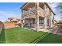 Charming backyard with a stone facade, artificial grass, and an outdoor cooking area perfect for entertaining at 2742 N Augustine --, Mesa, AZ 85207