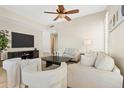 Neutral-toned living room features a ceiling fan, stylish decor, comfortable seating, and tiled flooring at 2742 N Augustine --, Mesa, AZ 85207