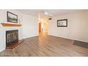 Living room with fireplace, wood floors, and view to hallway at 3249 W Maryland Ave, Phoenix, AZ 85017