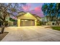 View of the front exterior featuring the garage and inviting entryway at dusk at 4332 E Vallejo Ct, Gilbert, AZ 85298