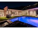 Night view of a luxurious pool and patio area at 7537 N Lakeside Ln, Paradise Valley, AZ 85253