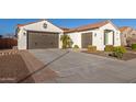 Two-car garage, landscaped yard, and neutral color scheme at 10496 W Cottontail Ln, Peoria, AZ 85383