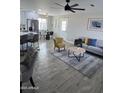 Bright living room with comfy seating and wood-look tile floors at 11411 E Crescent Ave, Mesa, AZ 85208