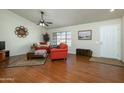 Living room features hardwood floors and orange couches at 12323 W Tigerseye Dr, Sun City West, AZ 85375