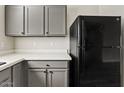 Well-equipped kitchen with gray cabinets and a black refrigerator at 1866 E Dust Devil Dr, San Tan Valley, AZ 85143