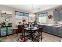 Eat-in kitchen with gray cabinets and a charming table setting at 18904 W Mercer Ln, Surprise, AZ 85388