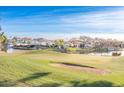 Picturesque view of a golf course and lake with houses in the background at 1942 W Peninsula Cir, Chandler, AZ 85248