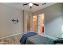 Cozy bedroom with light colored wood-look floors, ceiling fan, closet, and ensuite bathroom at 20552 W Carlton Mnr, Buckeye, AZ 85396