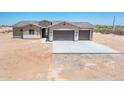 Single-story home featuring a two-car garage, desert landscaping, and neutral color palette at 21916 W Duane Ln, Wittmann, AZ 85361