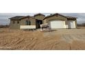 A single Gathering home with an unfinished front yard and a two car garage on a cloudy day at 21916 W Duane Ln, Wittmann, AZ 85361