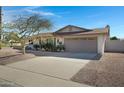 Front view of the house showcasing a large driveway and landscaping at 2543 E Manhatton Dr, Tempe, AZ 85282